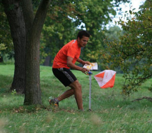 Man approaches marker point whilst orienteering